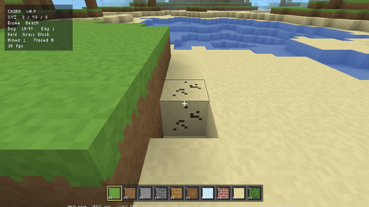 A Cairn world: a grass cliff over a sand beach and stepped blue water, with a targeted sand block mid-break showing its crack decals and wireframe outline.